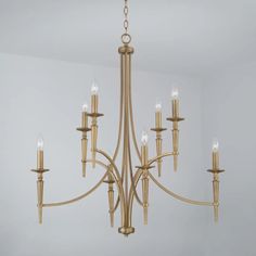 a gold chandelier with six lights hanging from it's center, in a room