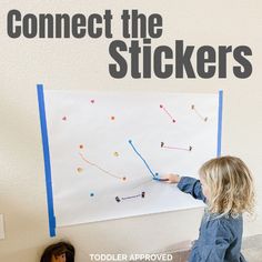 two children are playing with stickers on a white board that says connect the stickers