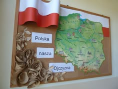 a bulletin board with different things on it and a flag hanging from the wall behind it