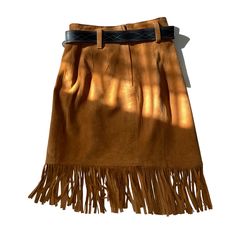 This 80s Cedars leather skirt features a western style with fringes and a belt. The soft leather material makes it comfortable to wear and the brown color gives it a classic look. The skirt is in great shape and has been well-maintained over the years. The skirt is a size 6 and fits true to size. The Cedars brand is known for their quality leather products and this skirt is no exception. Perfect for a vintage or western-inspired look, this skirt is a must-have for any fashion-forward individual. Brown Mini Skirt With Belt Loops, Fall Leather Mini Skirt With Belt Loops, Leather Skirt With Belt Loops For Fall, Fall Denim Skirt With Belt Loops, Western Style Brown Bottoms For Fall, Fall Brown Belted Skirt, Brown Fringe Mini Skirt, Chic Brown Fringe Skirt, Winter Sale