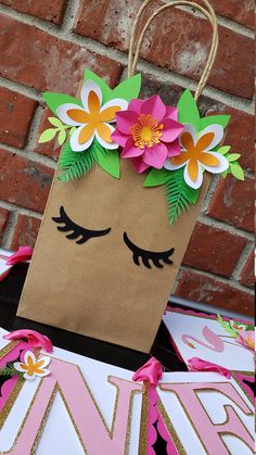 a brown paper bag with flowers on it sitting next to a brick wall and door