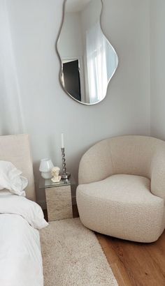 a bedroom with a chair and mirror on the wall