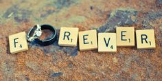 the word forever spelled with scrabble blocks and two wedding rings