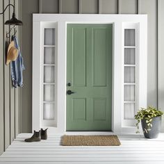 a white front door with two shelves on the side and a potted plant next to it