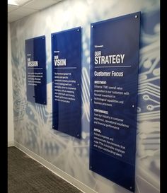 three blue signs on the wall in an office building with information about their strategy and how to use them