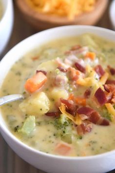 a white bowl filled with broccoli and ham soup next to bowls of potato chips