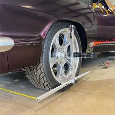 a car is parked in a garage with its tire being worked on by an electrician