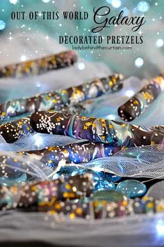 this is an image of some glass beads with sparkles on them and the words out of this world galaxy decorated pretzels