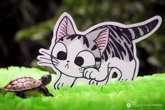 a cat and turtle sticker sitting on top of green grass