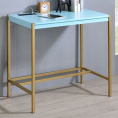 a blue desk with gold legs and a clock on it's shelf next to a window