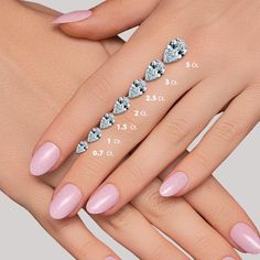 a woman's hand with pink manies and diamond rings on her fingers, showing the size