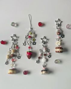 several different types of earrings hanging on a white surface with beads and charms attached to them