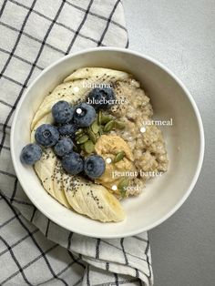 a bowl filled with oatmeal and blueberries on top of a towel