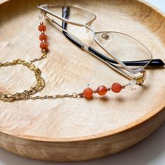 This is a one of kind eyeglass chain with faceted carnelian beads and glass Miyuki beads hung on a gold coloured metal chain. A great gift for a teacher, professor, librarian, artist or anyone who needs their glasses close at hand. Eyeglass chain features: Total chain length is approximately 29" Glass Miyuki beads are used as spacer beads Easily adjustable silicone eyeglass holders This is a delicate lightweight chain not meant for aggressive use *Eyeglasses in images are not included and used f Gift For Professor, Gifts For Professors, Carnelian Beads, Glasses Chain, Miyuki Beads, Eye Wear Glasses