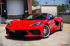 a red sports car parked in front of a garage