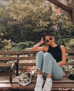 a woman sitting on top of a wooden bench