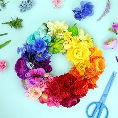 a bunch of flowers that are sitting on a table next to scissors and some paper