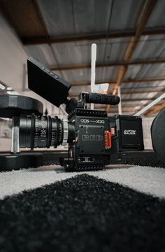 a video camera sitting on top of a carpet next to a black and white rug