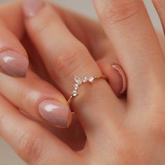 a close up of a person's hand with a ring on their finger and two diamonds in the middle