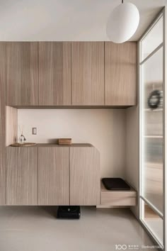 an empty room with wooden cabinets and a white light hanging from the ceiling above it