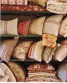 many pillows are stacked on shelves in a store