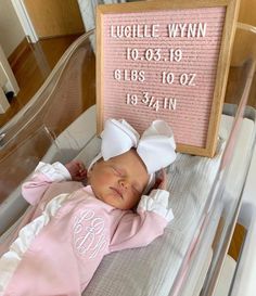 a baby is laying in a crib next to a sign