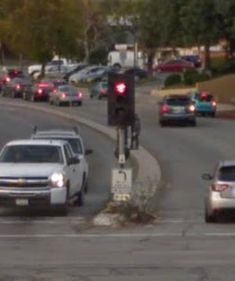 cars are stopped at a red light on a busy street