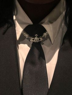 a man wearing a suit and tie with a crown on it's lapel