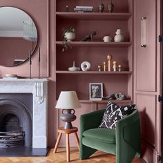 a living room filled with furniture and a fire place in front of a mirror on the wall