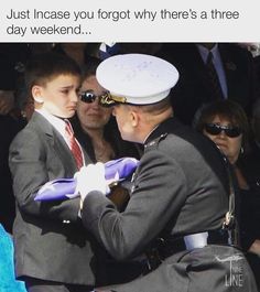 a man in a suit and tie is being pinned to another man's uniform