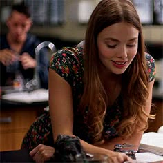 a woman sitting at a table with a laptop computer