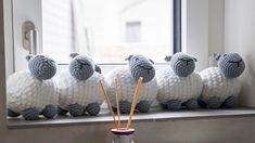 there are knitted sheep sitting on the window sill