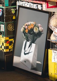 a white paper bag with flowers in it sitting on a shelf next to other boxes