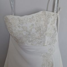 the back of a wedding dress hanging on a hanger with two scissors in it