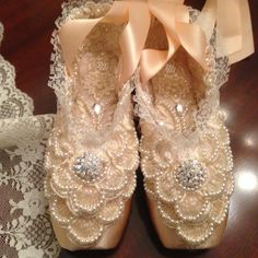 there is a pair of shoes that are on the table next to some lace doily