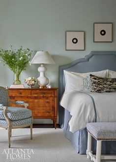 a bedroom with blue walls and white bedding