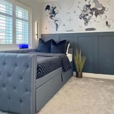 a bedroom with a large bed and a blue headboard on the wall next to a window