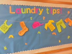 a bulletin board with laundry tips written on it and clothes hanging from a line attached to the wall