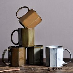 a stack of coffee mugs sitting on top of a table next to each other