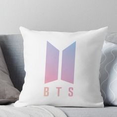 the bts logo is shown on a white pillow with pink and blue colors throw pillow