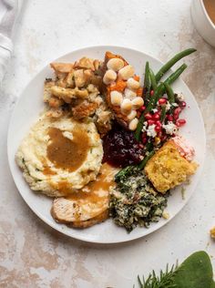 a white plate topped with different types of food next to a cup and saucer