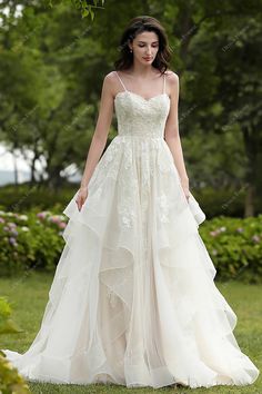 Soft and romantic, this lovely spaghetti strap fall wedding gown is accented in shimmery embroidered appliqués. A tulle over colored puffy A-line skirt with overlay flounce and horsehair edging reaches perfection. The illusion back with zipper closure and ruffled court train complete the look. #weddingdress #bridaldress #designerweddingdress #springweddingdress #fallweddingdress #autumnweddingdress #summerweddingdress #beachweddingdress #destinationweddingdress Cream Colored Wedding Dress, Custom Bridal Dress, Fall Wedding Gowns, Puffy Wedding Dresses, Princess Wedding Gown, Tulle Wedding Gown, Wedding Dress Champagne, Destination Wedding Dress, Affordable Wedding Dresses