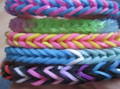 several different colored braided bracelets on someone's hand