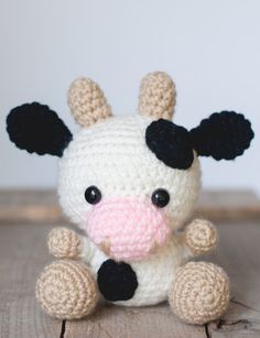 a small crocheted cow sitting on top of a wooden table