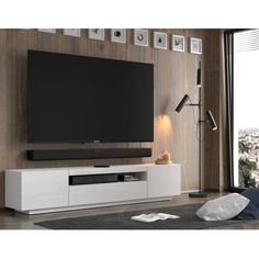 a flat screen tv sitting on top of a white entertainment center next to a window