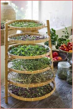 a wooden table topped with lots of different types of vegetables and herbs in baskets on top of it