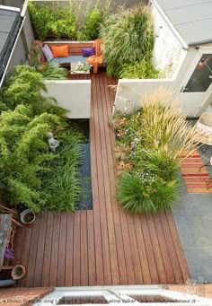 an aerial view of a small garden with wooden decking and plants in the foreground