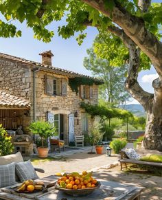 a bowl of fruit sitting on top of a wooden table next to a stone building