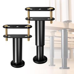 there are two black and gold poles next to each other on the floor in front of a wooden table