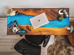 a wooden desk topped with a laptop computer next to a chair and other items on top of it